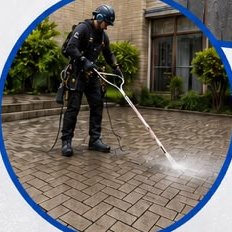 Technician pressure-cleaning block paving